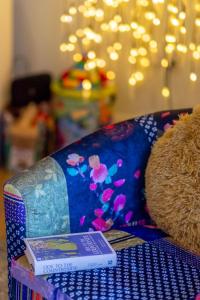 a teddy bear sitting on a couch with a book at Apartment Helland by Interhome in Pentewan