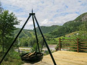 a swing on a deck with mountains in the background at Holiday Home Bjørnnåslia - SOW161 by Interhome in Åseral