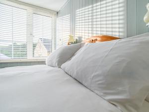 a white bed with white sheets and a window at Apartment Helland by Interhome in Pentewan