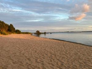 a sandy beach next to a body of water at Holiday Home Citta Romana by Interhome in Hellevoetsluis