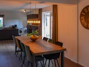a dining room table with chairs and a clock on the wall at Holiday Home Citta Romana by Interhome in Hellevoetsluis