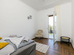 a white room with a bed and a chair in it at Apartment Johann 1 by Interhome in Balatonszárszó