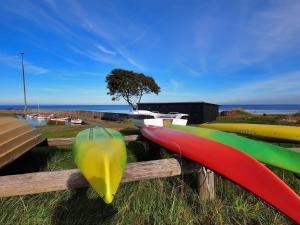 a row of surfboards on a fence with the ocean in the background at Apartment Thera - 5km from the sea in Bornholm by Interhome in Gudhjem