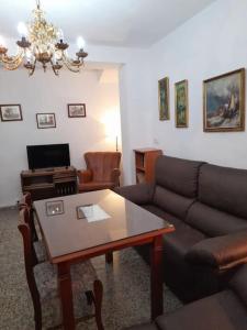 sala de estar con sofá y mesa en Casa Mis Abuelos, en Priego de Córdoba