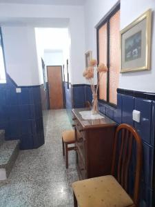 Habitación con paredes azules, escritorio y sillas. en Casa Mis Abuelos, en Priego de Córdoba