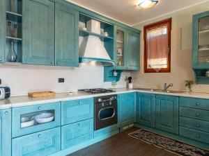 a blue kitchen with blue cabinets and a sink at Apartment Dada by Interhome in Domaso