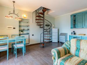 a living room with a table and a spiral staircase at Apartment Dada by Interhome in Domaso