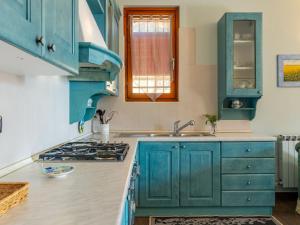 a kitchen with blue cabinets and a sink at Apartment Dada by Interhome in Domaso +23 photos
