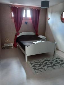 a bedroom with a bed with purple curtains and a rug at Pont-de-poitte: Appart'Alice in Pont-de-Poitte