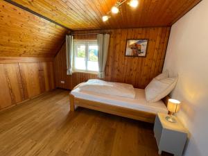 ein Schlafzimmer mit einem Bett in einem Holzzimmer in der Unterkunft Holiday Home Landhaus Klara by Interhome in Eisenbach