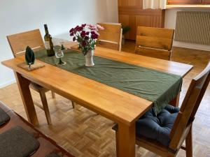 einen Holztisch mit einer Blumenvase darauf in der Unterkunft Holiday Home Landhaus Klara by Interhome in Eisenbach
