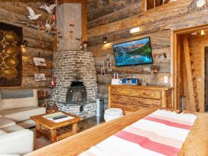 a living room with a fireplace in a log cabin at Holiday Home Lymys by Interhome in Saariselka