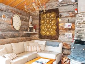 a living room with a couch and a clock on the wall at Holiday Home Lymys by Interhome in Saariselka