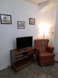 sala de estar con silla y TV de pantalla plana en Casa Mis Abuelos, en Priego de Córdoba