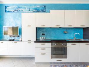 a kitchen with white cabinets and a sink at Apartment Blue Moon by Interhome in Santo Stefano al Mare