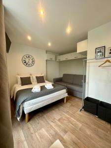 - une chambre avec un lit, un canapé et un réveil dans l'établissement *Studio 2* Avenue Baudin - DABNB, à Limoges