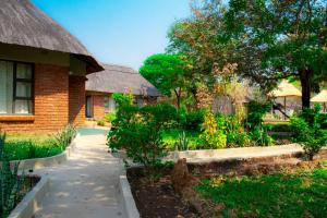 un jardin en face d'une maison avec un bâtiment dans l'établissement iroCK Lodge, à Victoria Falls
