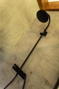 a black microphone sitting on a concrete floor at Fagoaga dorretxea in Ergoyen