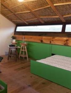a green room with two beds and a table at Be and See in Nature in Ovar
