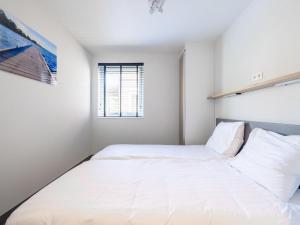 UitgeestにあるApartment Westergeest Luxe by Interhomeの大きな白いベッドと窓のある寝室
