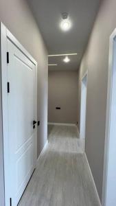an empty hallway with a white door and a hallwayngth at Cozy 2 room apartment in city center in Almaty