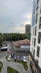 a group of cars parked in a parking lot next to a building at Cozy 2 room apartment in city center in Almaty