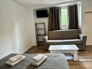 uma sala de estar com um sofá e uma cadeira em *Studio 1* Avenue Baudin - DABNB em Limoges