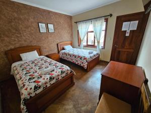um quarto de hotel com duas camas, uma secretária e uma mesa em Hotel Posada de María em Cuenca