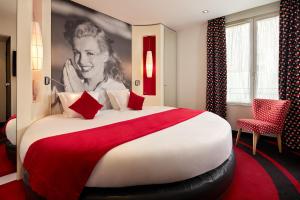 Pokój hotelowy z dużym łóżkiem z kobietą na ścianie w obiekcie Platine Hotel w Paryżu