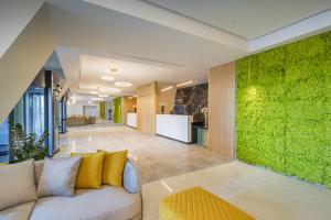 a living room with a couch and a green wall at Barceló Fortina Malta in Sliema