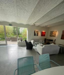 uma sala de estar com sofás e cadeiras num quarto em Polderlicht em Blankenberge