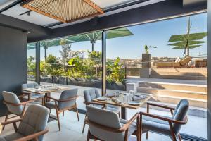 a restaurant with tables and chairs and large windows at Barceló Fortina Malta in Sliema