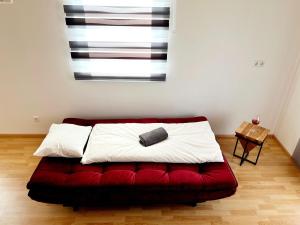 łóżko z czerwoną kanapą w pokoju w obiekcie Holiday Home Hakuna Matata with sauna w Spielbergu