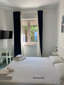 帕利努罗Il Gabbiano Palinuro的卧室里有一张白色的大床和一扇窗户 更多271张照片