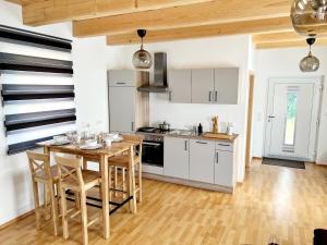 kuchnia z białymi szafkami i drewnianym stołem w obiekcie Holiday Home Hakuna Matata with sauna w Spielbergu