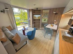 un soggiorno con divano e tavolo di Tiny house with terrace and lake view a Neunburg vorm Wald