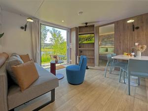 a living room with a couch and a table at Tiny house with terrace and lake view in Neunburg vorm Wald