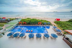 uma vista aérea de um resort com uma piscina e uma praia em Slaviero Ingleses Convention em Florianópolis