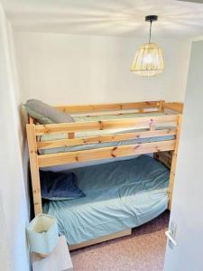 drewnianym łóżkiem piętrowym w jasnym pokoju w obiekcie Winter Cocon w mieście Mijoux
