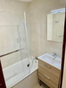 uma casa de banho com um chuveiro, um lavatório e uma banheira em Winter Cocon em Mijoux