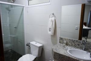 a bathroom with a toilet and a sink and a shower at Hotel Lafayette in Itaquaquecetuba