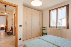 1 Schlafzimmer mit 2 Betten, einem Schrank und Stühlen in der Unterkunft Villetta Grazia in Cascina