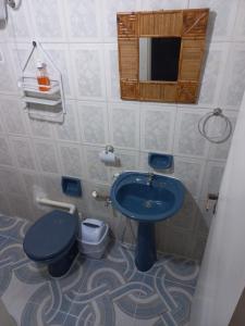 La salle de bains est pourvue d'un lavabo bleu et de toilettes. dans l'établissement Departamento Completo, 3 habitaciones. Excelente ubicación, à Asuncion
