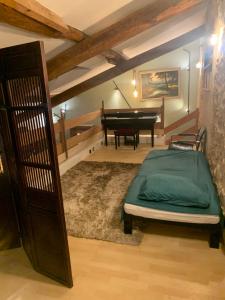 um quarto com uma cama e um piano numa sala em Villa Baptiste Spa Sauna Billard Piano ping-pong Piscine près de Bordeaux em Cérons