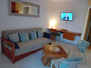 una sala de estar con un sofá y una mesa en Appartement T2 climatisé La pépite, en Saint-François