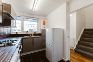 a kitchen with a white refrigerator and a staircase at Shadwell Double Room - 13 in London