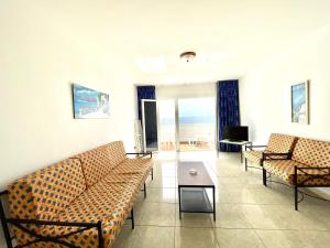 a living room with couches and a view of the ocean at Oceanfront apartment a few meters from the beach in Tamaduste