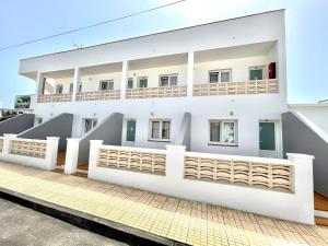 Edificio blanco con balcón en Oceanfront apartment a few meters from the beach en Tamaduste