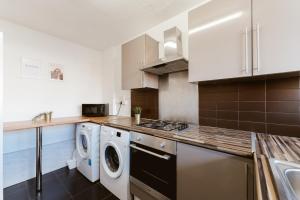a kitchen with a washer and dryer in it at Shadwell Double Room - 13 in London