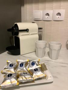 a coffee maker and some cups on a counter at The Acropolis Cave Apartment in Athens